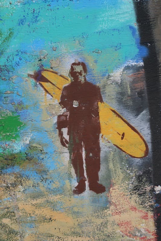Surfer With Longboard Against Layered Wall